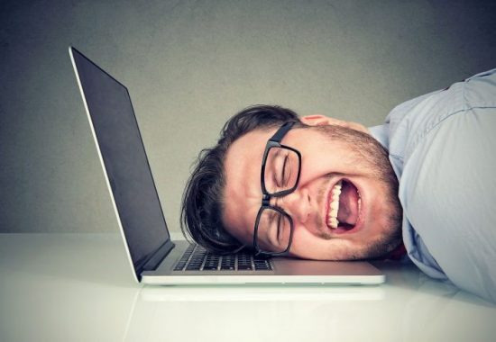 Frustrated-Looking Man Leaning On His Laptop Keyboard