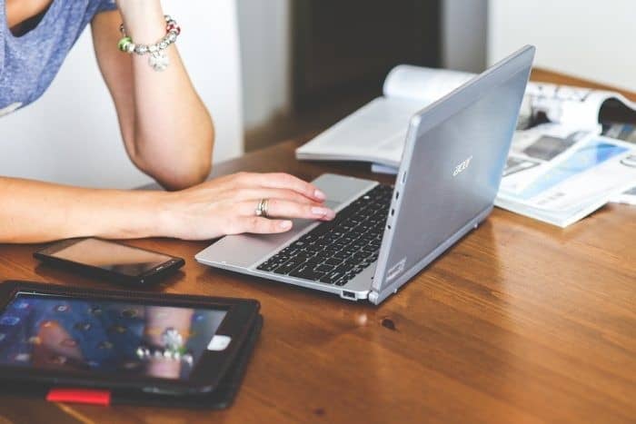 Woman Working At A Desk With A Laptop And A Tablet Beside Her