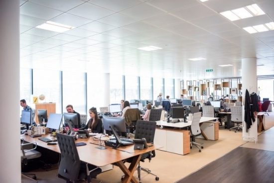 Workers Sat At Their Desks In An Open Plan Office