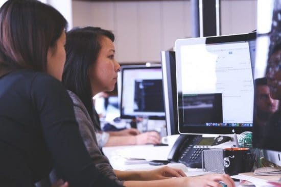 Two Women Working From a Shared Computer Screen