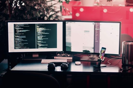 Two Computer Screens Side-by-Side on a Desk