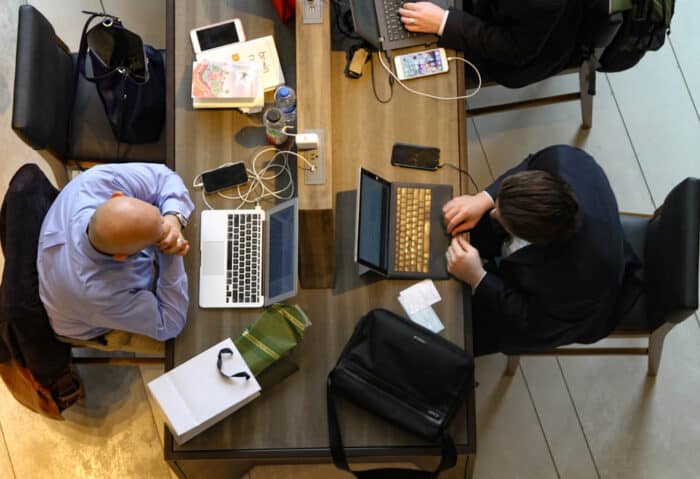 Overhead view of two men working on laptops.